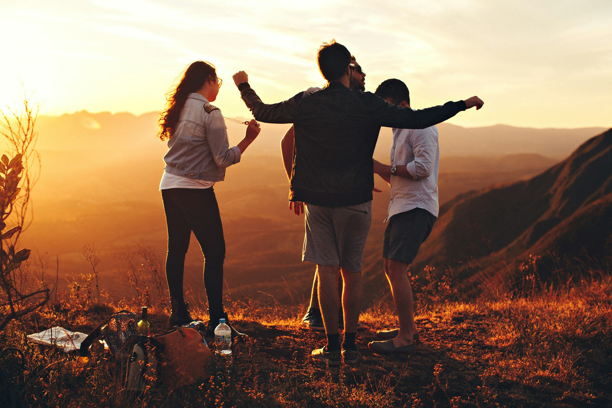 Friends celebrating on a hillside at golden hour